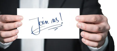 Person holding a letter with the sentence "Join us!"